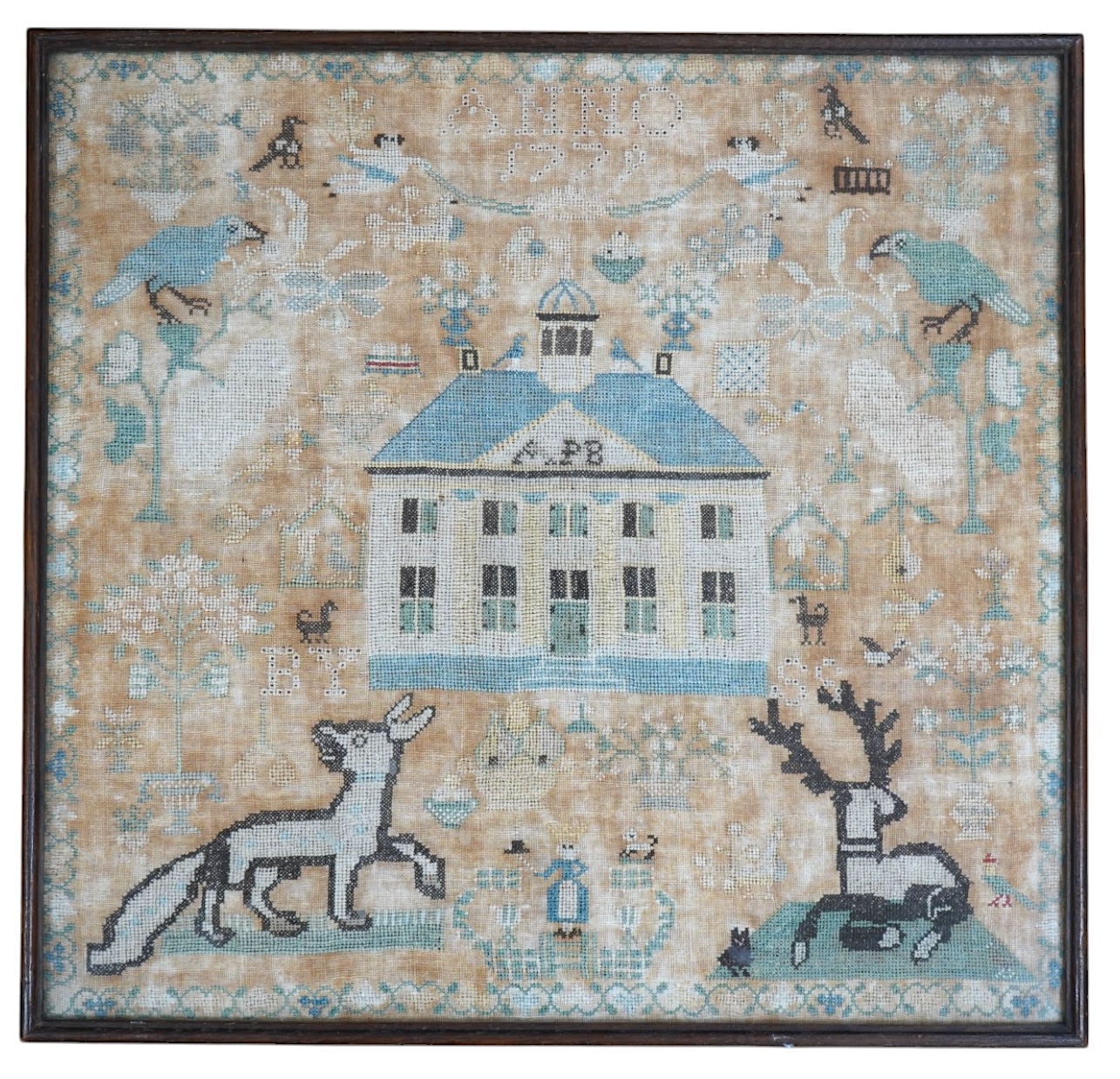 A framed 18th century sampler, dated 1779 by SS., worked in fine cross stitch with motifs of angels, figures, flowers, trees birds a fox and a stag surrounding a house with initials APB. 39cm x 37.5cm. Condition - the em